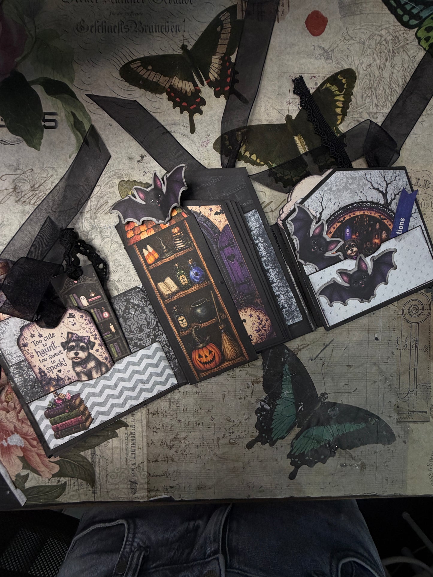 Howl-O-Ween Manor junk journal folio opened to reveal interactive pockets, tags, spooky bats, ribbons, and Halloween paper details.