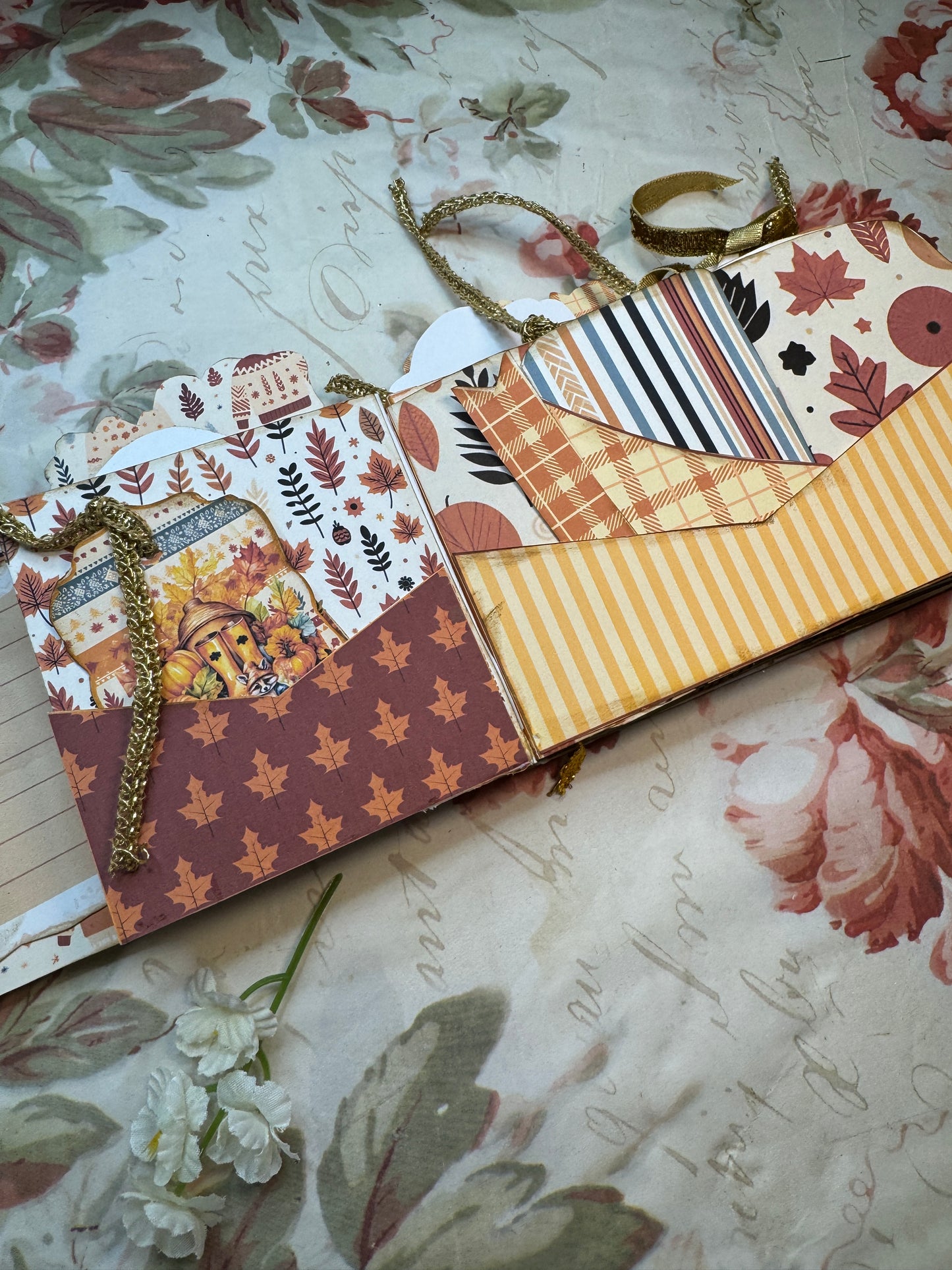 Decorative paper strip with autumn-themed patterns on a floral background