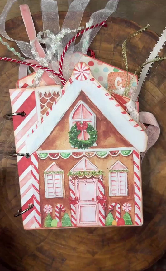 20-second flip-through video of the handmade "Gingerbread Dreams" Christmas junk journal folio. The video shows the gingerbread house–shaped cover with festive ribbons, then flips through decorated inside pages featuring gingerbread men, candy canes, pockets, journaling cards, and Christmas-themed embellishments.