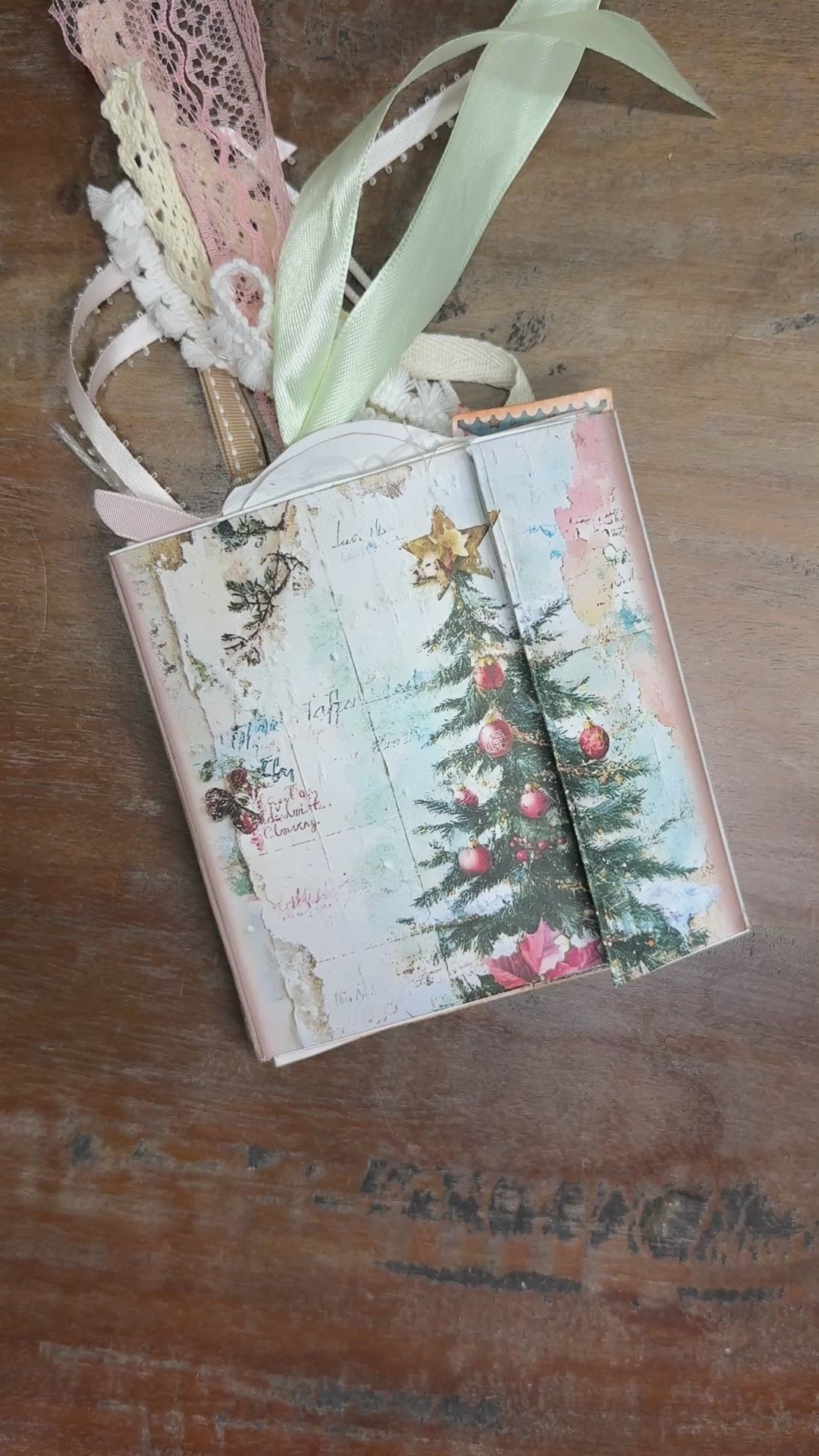 Flip-through video of a handmade Nutcracker-themed Christmas junk journal folio. The video shows the vintage-style cover with a nutcracker soldier and Christmas tree, then opens to decorated pages filled with nutcrackers, ballerinas, ornaments, tags, journaling cards, and pastel holiday embellishments tied with lace and ribbon.