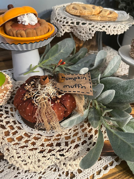 Primitive fall décor—fabric pumpkin muffin in canning ring with coffee-grunge finish, cheesecloth topper, and “pumpkin muffin” tag on a crochet doily.