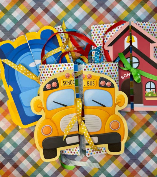 Colorful Back to School Keepsake Folio Journals with School Bus, Red Schoolhouse, and Blue Backpack covers, tied with ribbon, on a plaid background
