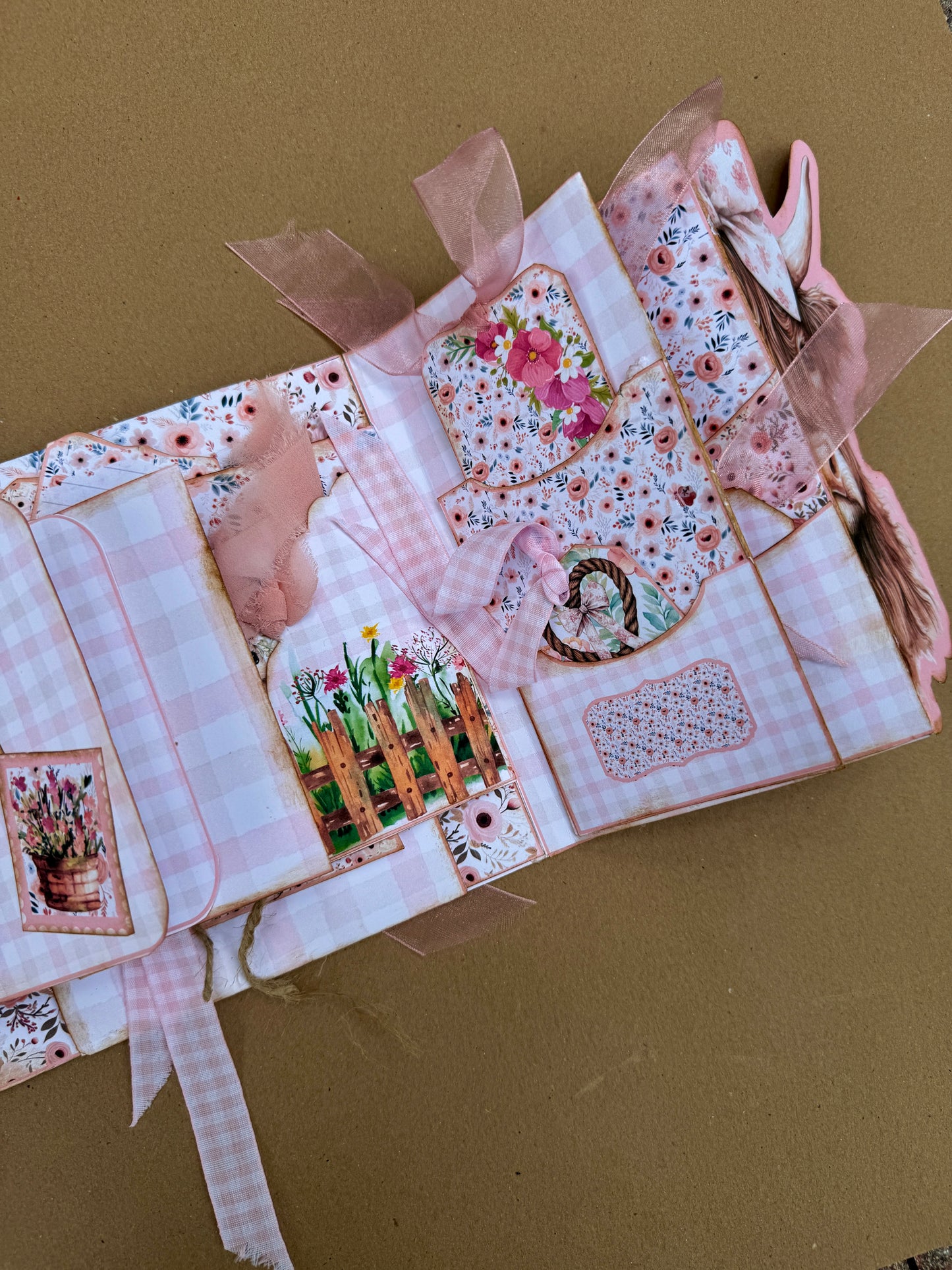 Cow-themed journal folio with pink floral pockets, ribbon-tied tags, and memory-keeping cards