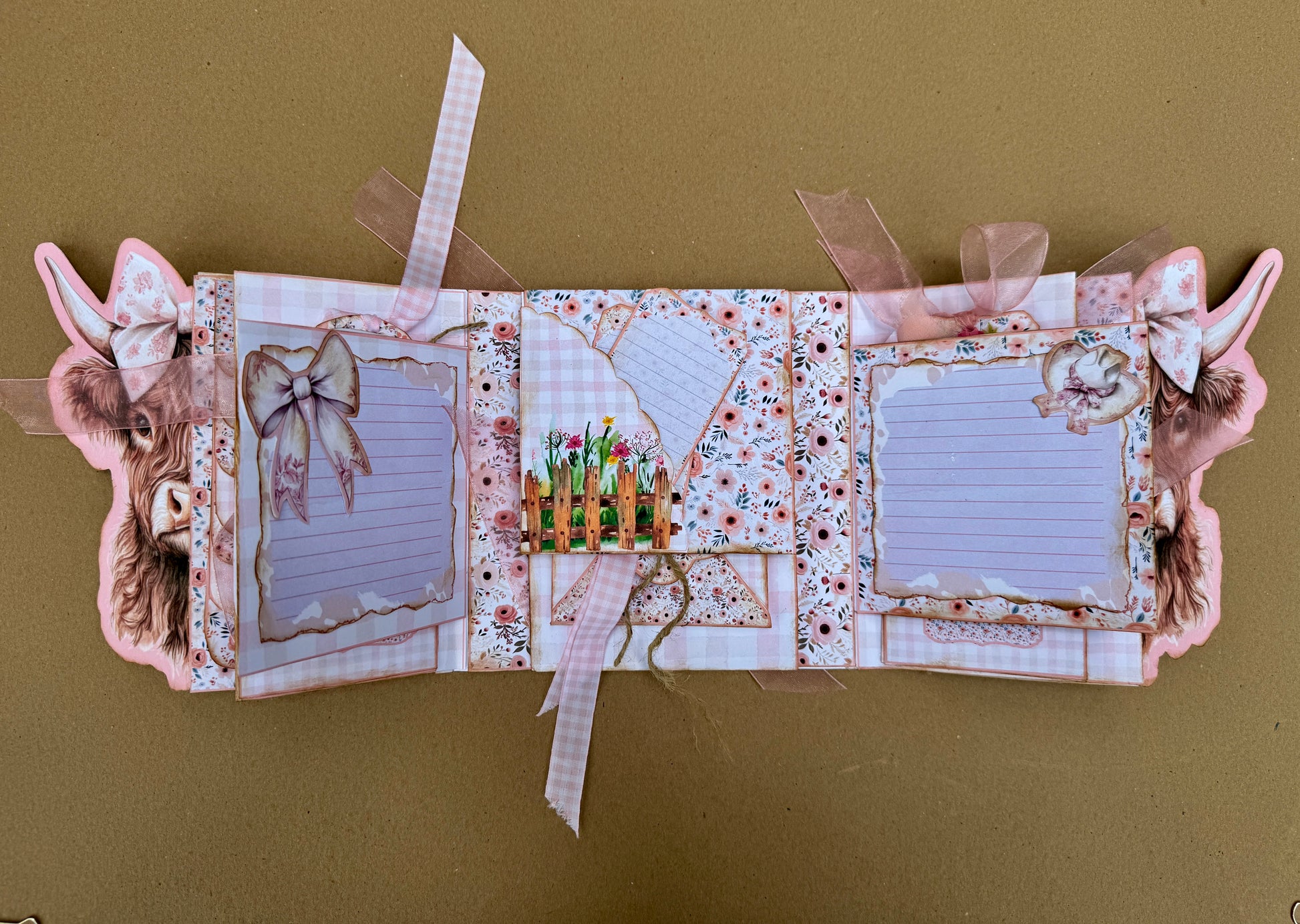Open Highland cow journal folio with floral pages, writing cards, pockets, and foldout sections