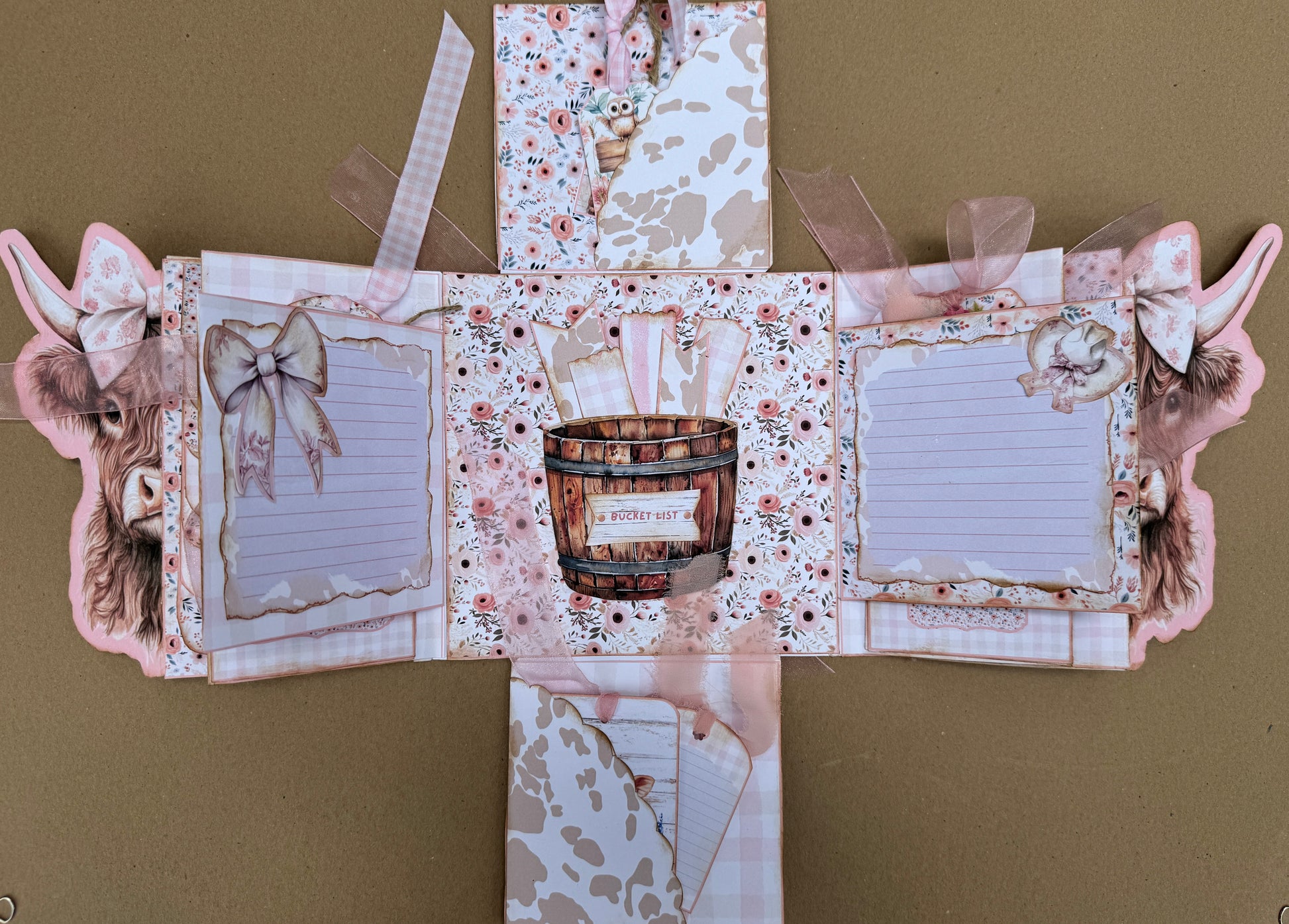 Pink gingham cow journal with layered pockets, tags, photo mats, and floral paper details